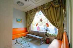 A room with a sofa, a glass table, and a window with curtains. - OK Boutique Hotel (Shanghai)
