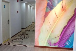 A hotel corridor with a carpeted floor and a wall with a feather mural. - OK Boutique Hotel (Shanghai)