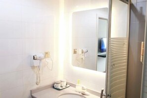 A modern bathroom with a large mirror, a hairdryer, and a sink. - OK Boutique Hotel (Shanghai)