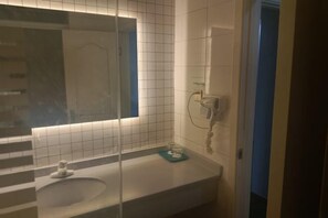 A bathroom with a white sink, a mirror, and a towel rack. - OK Boutique Hotel (Shanghai)