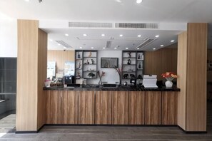 A reception desk with a wooden panel design, a black countertop, and framed artwork on the wall. - OK Boutique Hotel (Shanghai)