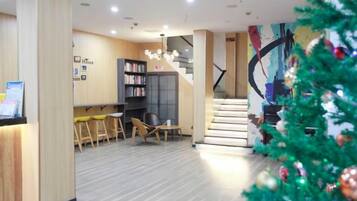A modern interior with a staircase, a reception desk, and a Christmas tree.
