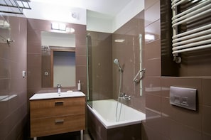 A modern bathroom with a vanity, a shower, and a towel rack.