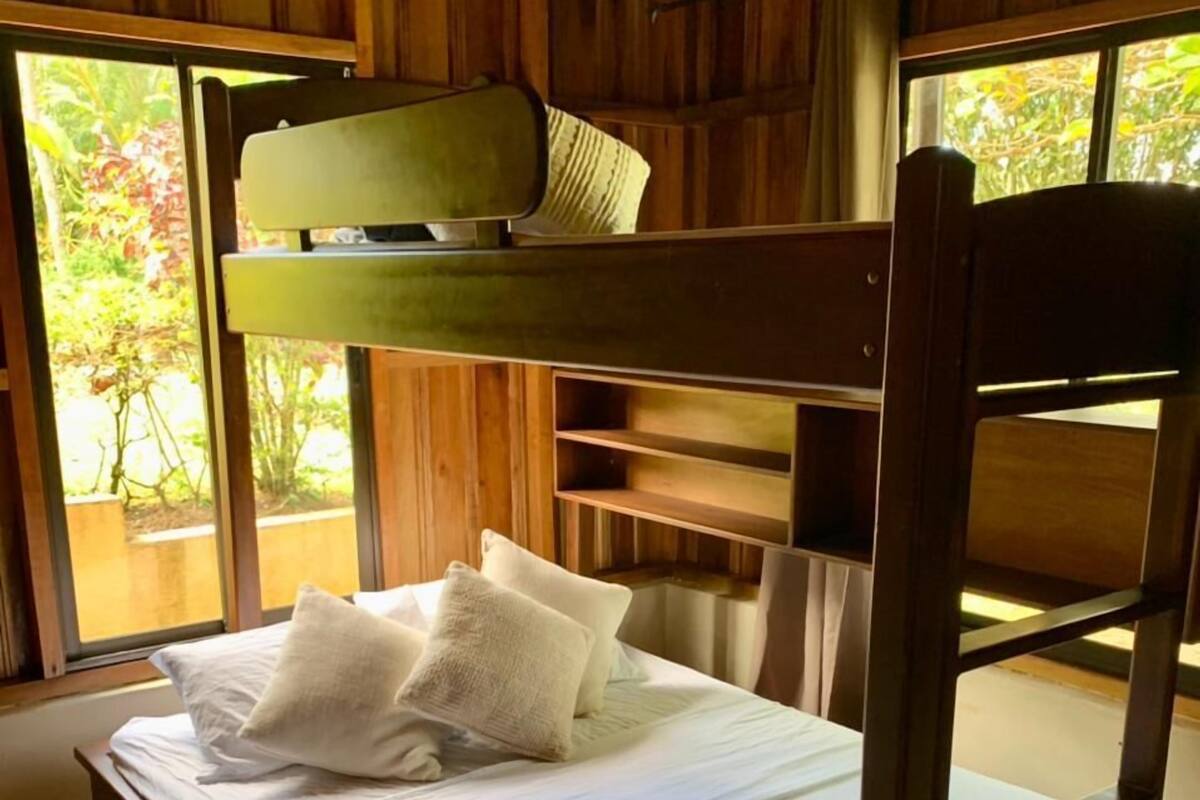 A bunk bed with a wooden frame and white bedding.