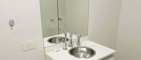 A modern bathroom with a glass-enclosed shower, a double sink, and a large mirror.