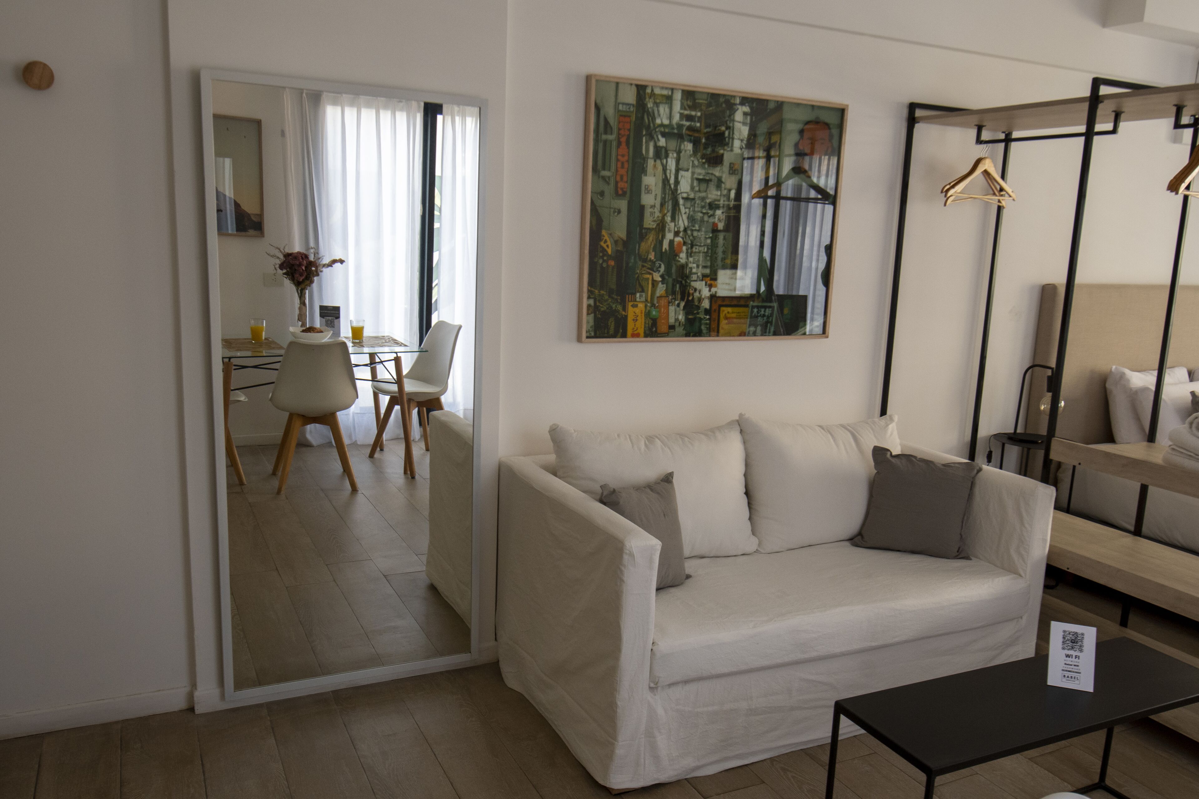 A modern living room with a sofa, a coffee table, and a dining area with chairs and a table.
