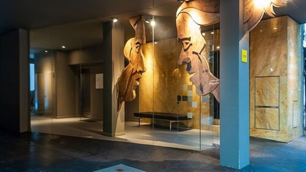 A modern interior with a glass display case containing a large sculpture. - Babel Belgrano (Buenos Aires)