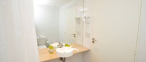 A bathroom with a white sink, mirror, and a white door.