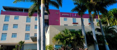 A hotel building with multiple floors, a flat roof, and a sign indicating it is a hotel.