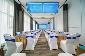 A conference room with rows of tables and chairs, large screens at the front, and a carpeted floor. - Peng Ke Boutique Hotel (Shenzhen Baoneng Center Sungang Subway Station Branch) (Shenzhen)