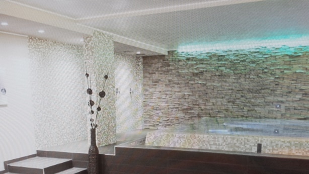 A modern interior with a stone wall, a staircase, and a minimalist design.