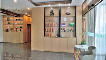 Vestíbulo de hotel con mostrador de recepción, área de estar y exhibición de productos.