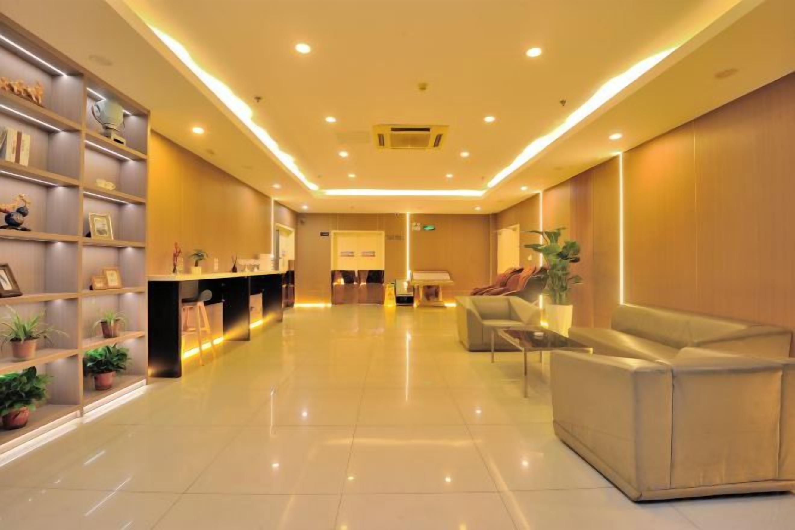 A hotel lobby with a reception desk, seating area, and a reception counter.