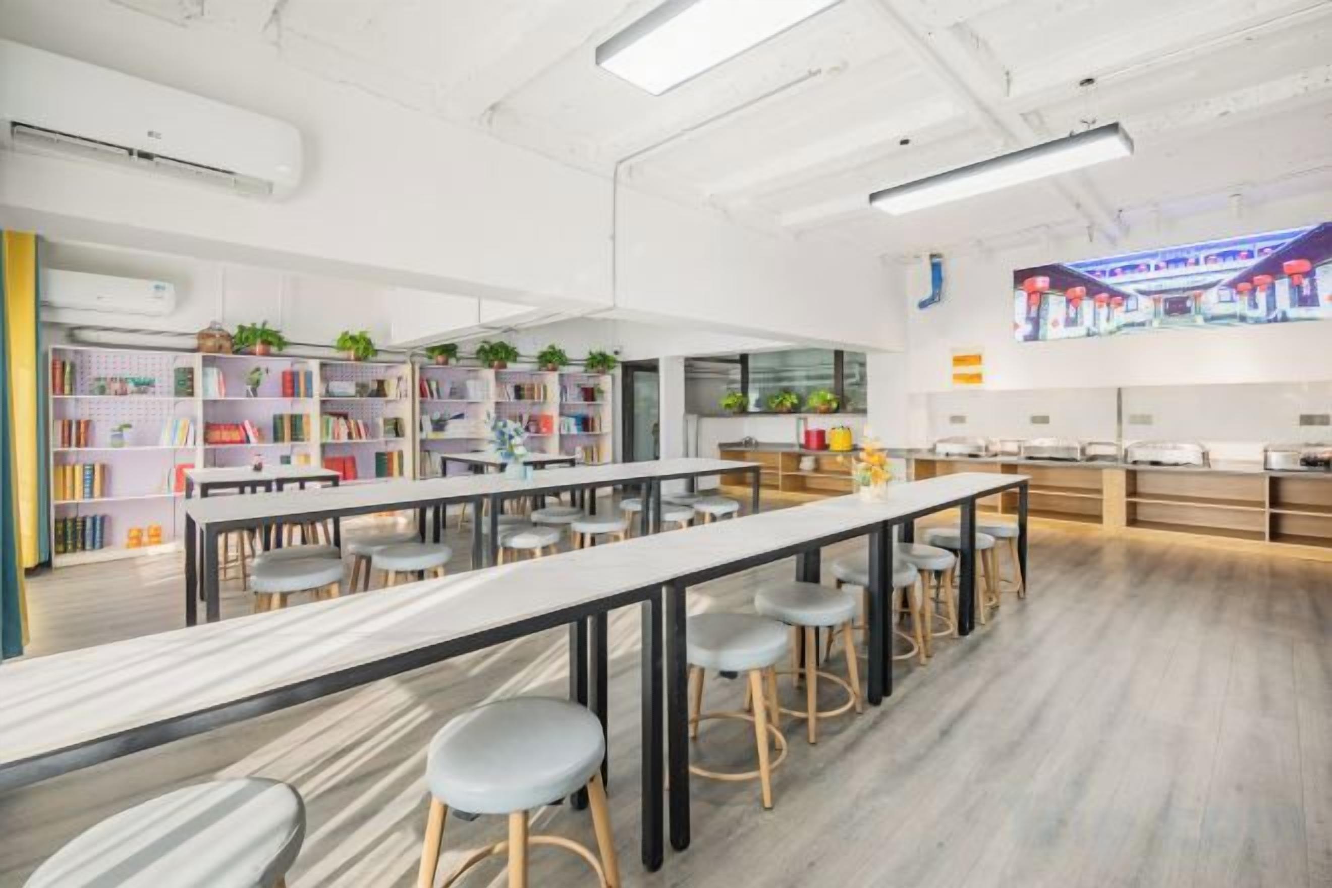 Una biblioteca moderna con estanterías, mesas y taburetes.