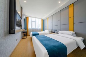 Una habitación de hotel con dos camas, un escritorio y un ventanal grande.