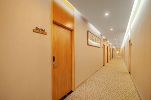 A hotel hallway with doors numbered 8906 and 8907, a patterned carpet, and recessed lighting. - OTA short name: Mingyang Hotel (Taiyuan South Railway Station · Shanxi University Branch) (Taiyuan)