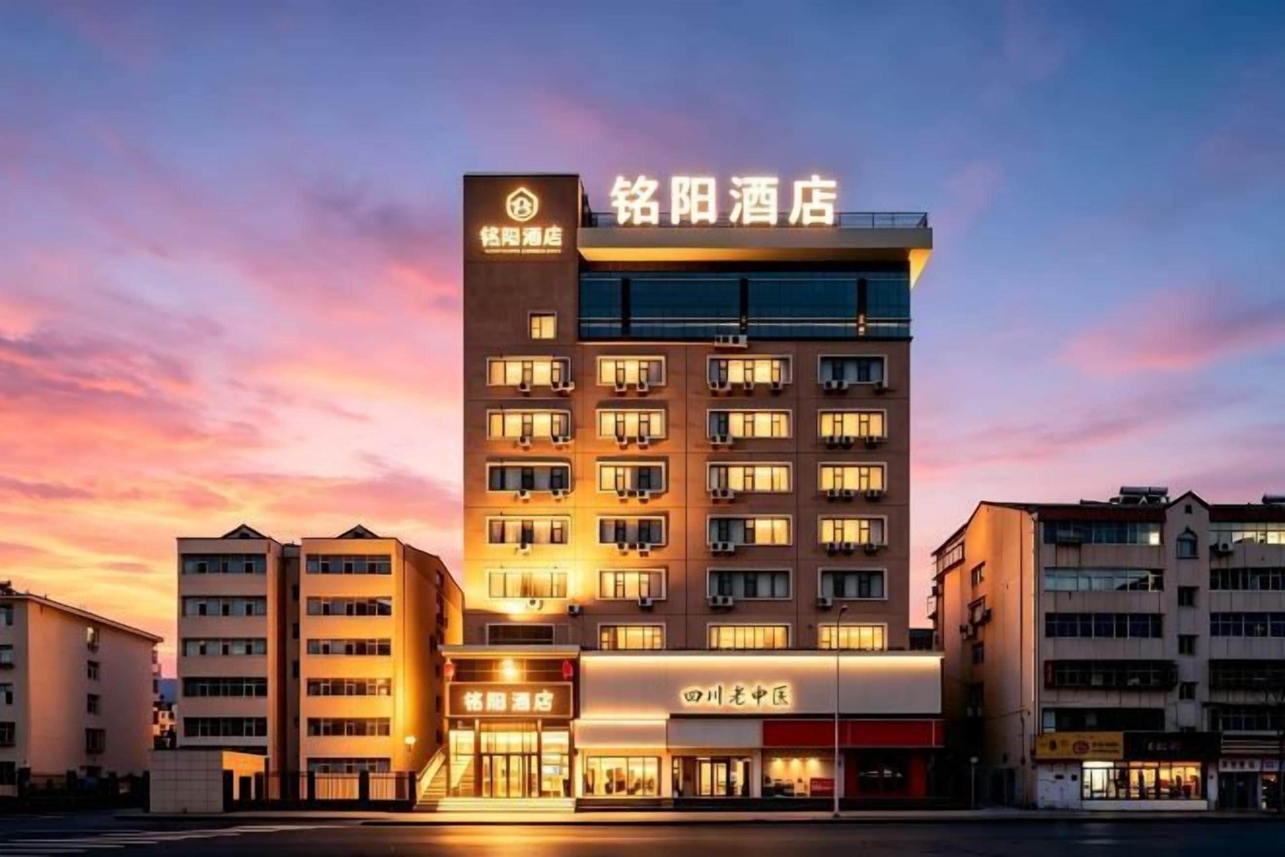 Un hôtel à étages, doté d’une enseigne bien visible et d’une façade bien éclairée.