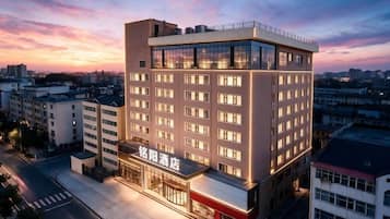 Un hotel moderno a più piani, con un ingresso ben visibile e un'ampia facciata in vetro.