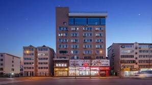 A multi-story hotel with a modern design, featuring a prominent entrance with illuminated signage, a flat roof, and a series of windows on each floor. - OTA short name: Mingyang Hotel (Taiyuan South Railway Station · Shanxi University Branch) (Taiyuan)