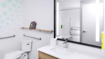 A modern bathroom with a white toilet, a sink with a mirror, and a towel rack.