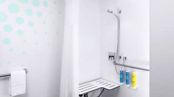 A shower area with a showerhead, a towel rack, and a shelf with toiletries.