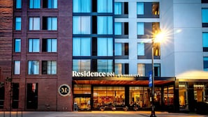 Un hôtel à plusieurs étages, doté d’une façade moderne, de grandes fenêtres et d’une entrée bien visible.