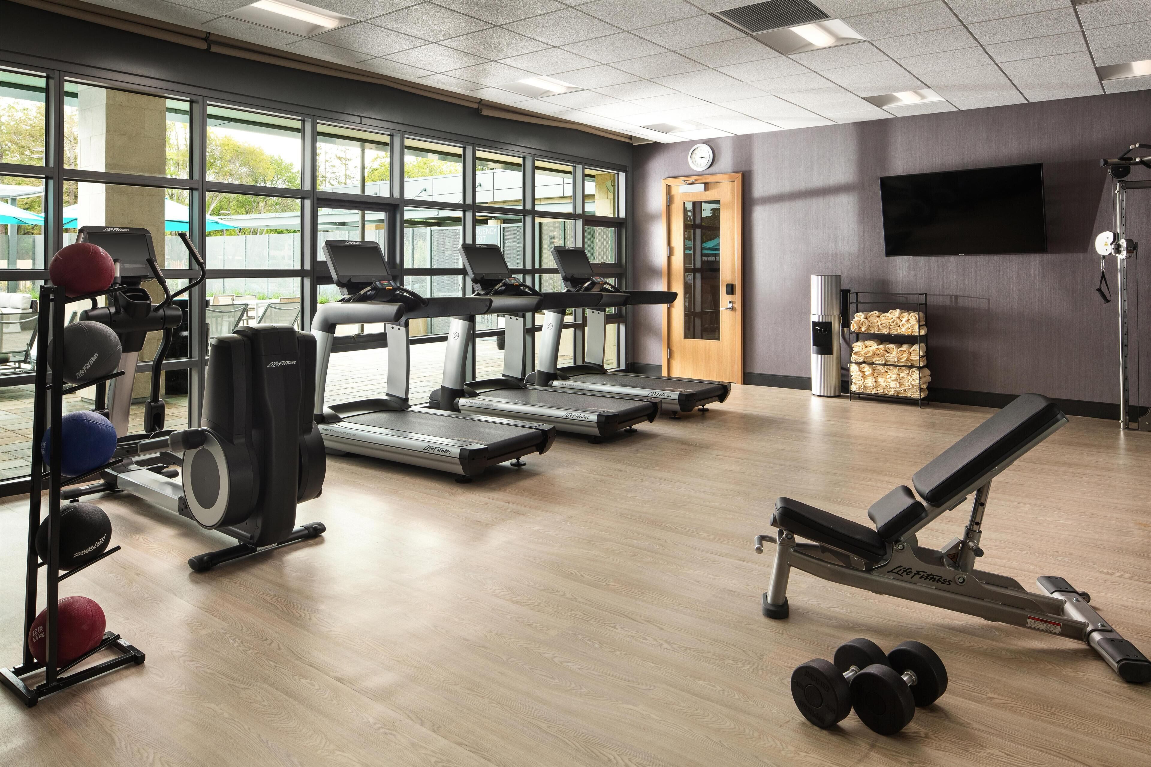 A gym with treadmills, weight machines, and exercise balls.