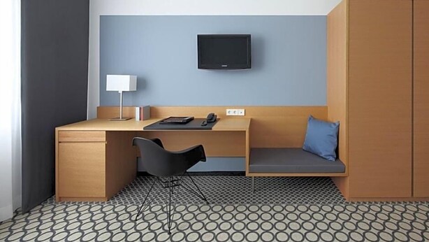 A compact hotel room with a desk, chair, TV, and wardrobe. - Hotel Otterbach (Bietigheim-Bissingen)