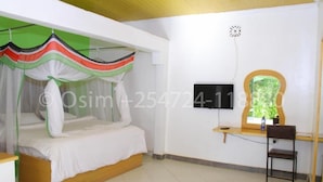 A bedroom with a bed, a desk, a chair, and a TV. - Osim Country Lodge (Ewaso Ngiro)