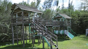 A wooden play structure with a slide and stairs. - Osim Country Lodge (Ewaso Ngiro)