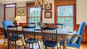 A dining room with a wooden table, six chairs, and a chandelier. - Nantucket Private Oasis - 6BR Pet-Friendly Home, Short Drive to Quidnet Beach (Nantucket)