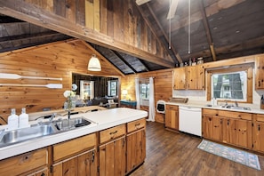 Una cocina amplia con armarios de madera, una isla grande y vistas al exterior.