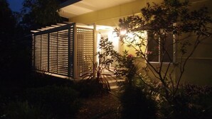 A modern house with a covered porch and a garden. - Retro Beach House on Pearl Beach (Pearl Beach)