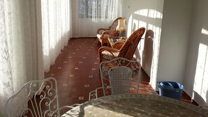 A sunlit room with a tiled floor, wicker furniture, and a view through a window. - 5 DBR villa.Dual level with own pool. Walking distance to Calpe's Levante beach (Alicante)