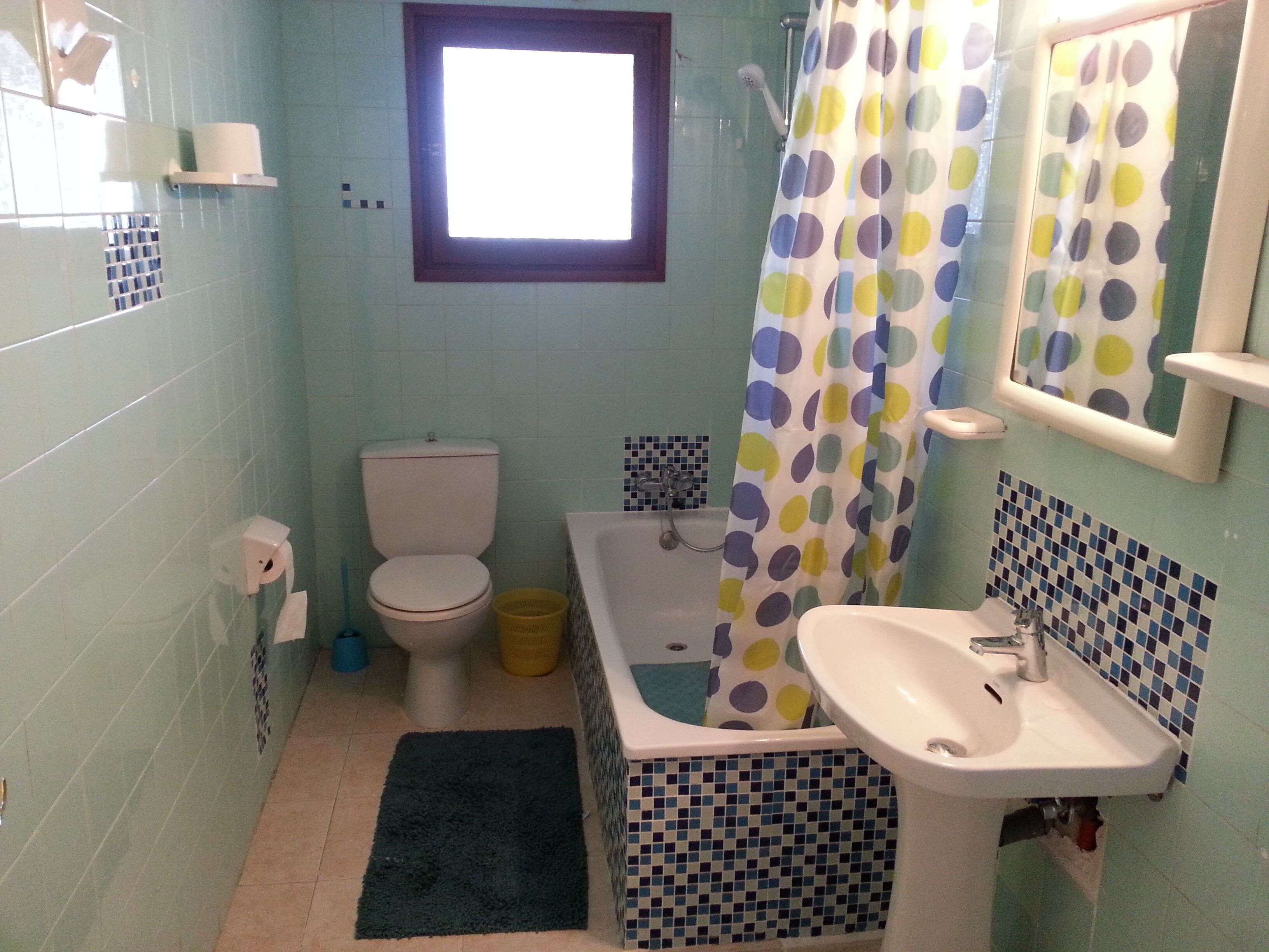 Een badkamer met toilet, bad en wastafel.