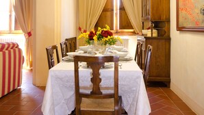 A dining area with a table set for four, surrounded by chairs, a chandelier, and a window with curtains. - || NEW Incredible View || Piazza della Signoria apt! (Firenze)