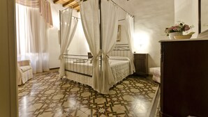 A bedroom with a four-poster bed, a wooden ceiling, and a patterned floor. - || NEW Incredible View || Piazza della Signoria apt! (Firenze)
