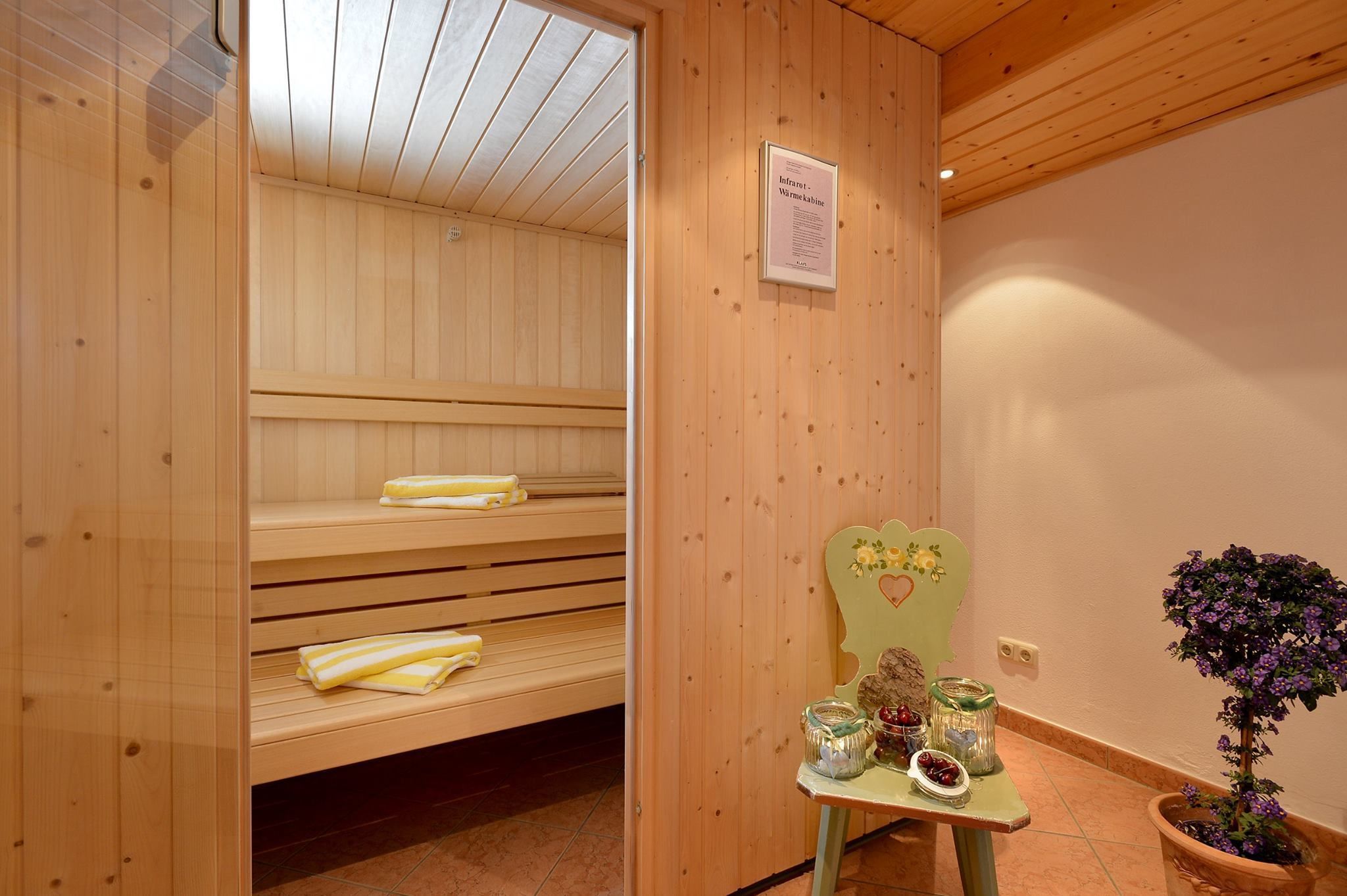 A wooden sauna with benches and a table with jars of berries.