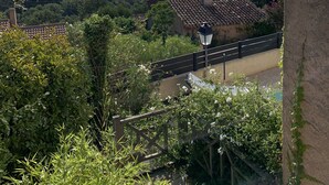 A view of a rural landscape with a traditional house, a bridge, and surrounding greenery. - Hillside Village House with Stunning Views toward St Tropez (La Garde-Freinet)