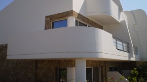 A modern building with a unique architectural design, featuring a curved facade and a prominent overhang. - Seaview Villa. Quiet and peaceful, relax and chill out (Lassithi)