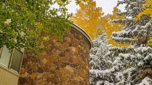 A stone building with a wooden door, surrounded by snow-covered trees and a clear sky. - Ski In/Ski Out + Private Hot Tub + Sleeps 8 + Free Parking  (Keystone)