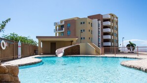 Un hôtel moderne doté d’une piscine, d’un toboggan et d’une clôture en bois.