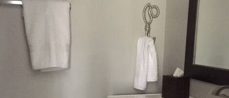 A bathroom with a toilet, a sink, and a mirror.