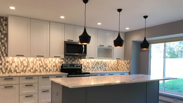 A modern kitchen with a large island, white cabinetry, and a patterned backsplash. - Super close to campus and Lloyd Noble Center. Clean home with updated kitchen. (Norman)
