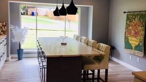 A modern kitchen with a central island, pendant lighting, and a view of the outdoors. - Super close to campus and Lloyd Noble Center. Clean home with updated kitchen. (Norman)