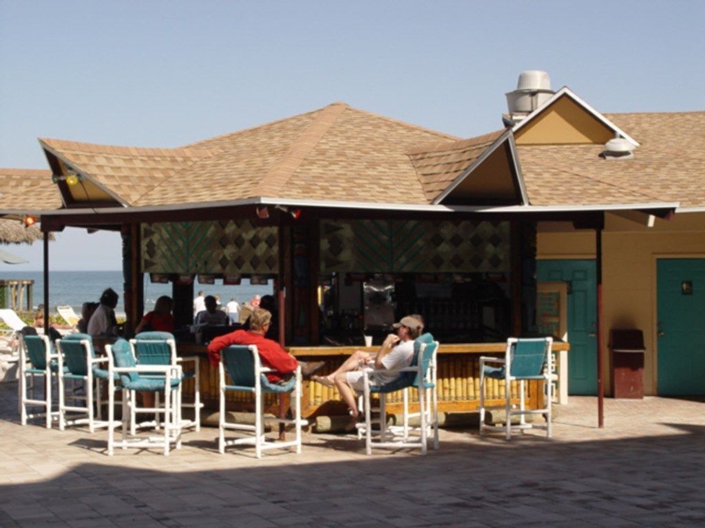 Un bar situé au bord de la plage, avec des tables en plein air.