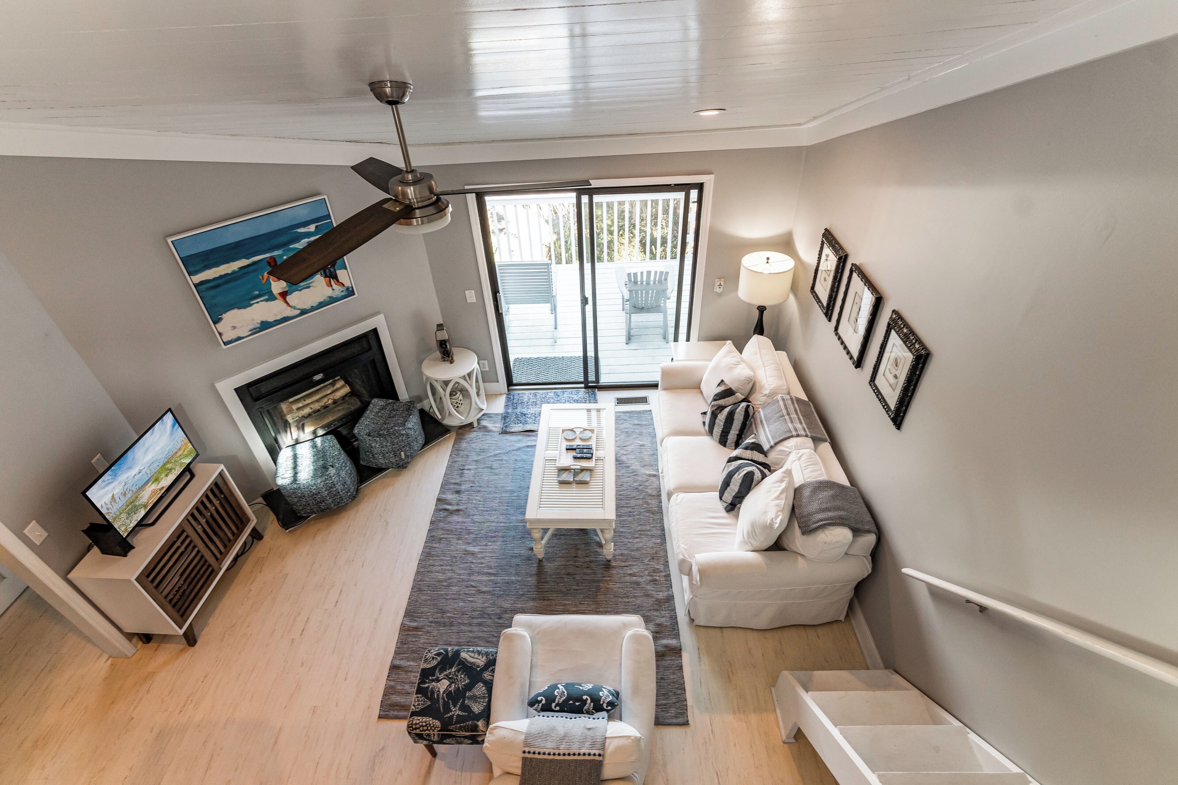 A modern living room with a fireplace, a sofa, a coffee table, and a television.