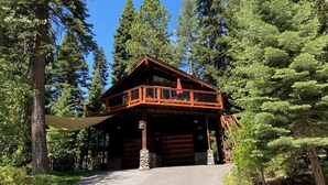 A log cabin with a balcony, surrounded by tall trees. - North Lake Tahoe, Mountain/Lake Views, Hot tub, Walk to Beaches, Vacation Rental (Tahoe Vista)