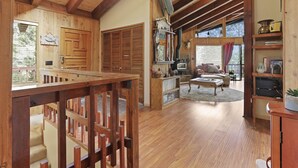 A rustic cabin interior with wooden floors, a fireplace, a dining area, and a cozy seating space. - North Lake Tahoe, Mountain/Lake Views, Hot tub, Walk to Beaches, Vacation Rental (Tahoe Vista)