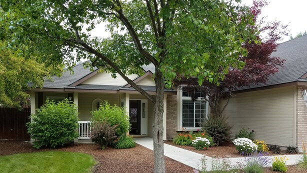 A residential house with a front porch, a covered entryway, and a landscaped garden with various shrubs and flowers. - Eagle ~ Great Sky Neighborhood ~ 4-Bdrms  ~ Near Pool & Shopping ~ ALL Amenities (Eagle)